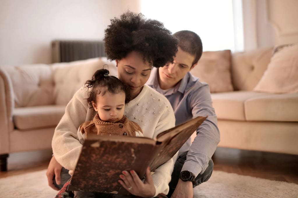photo of woman holding brown book with her child